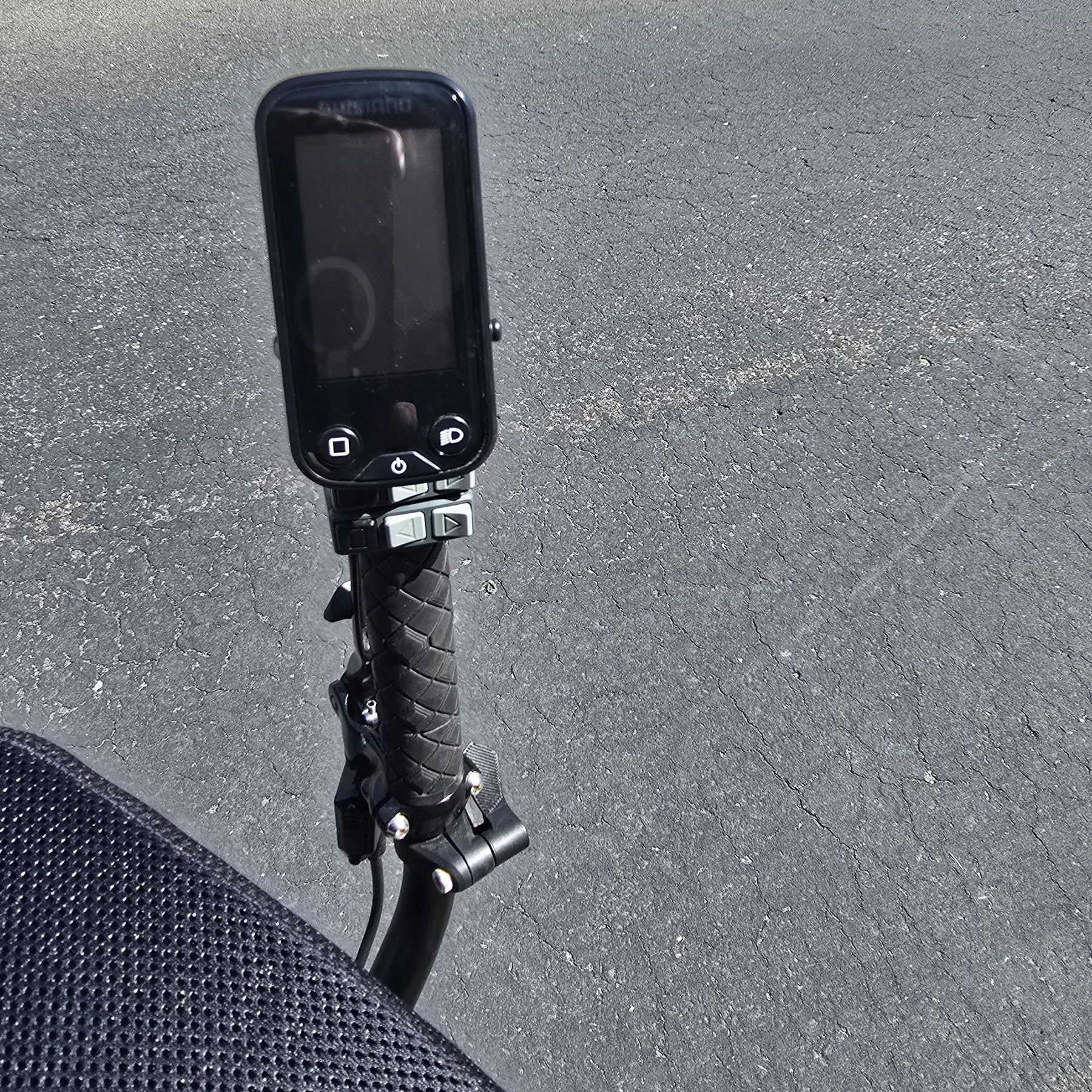 Closeup view of the handlebar and e-assist console on the Hase Used 2022 Kettwiesel Evo Steps 6100 with 630wh Battery and 2A Charger Recumbent Trike in an outdoor setting.
