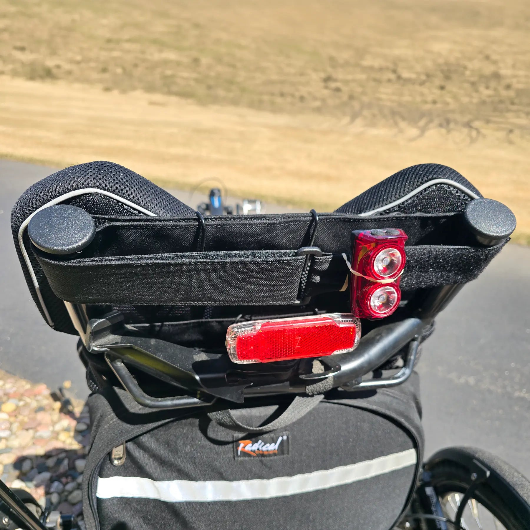 Closeup view of the seat bag and two taillights on the Hase Used 2022 Kettwiesel Evo Steps 6100 with 630wh Battery and 2A Charger Recumbent Trike in an outdoor setting.