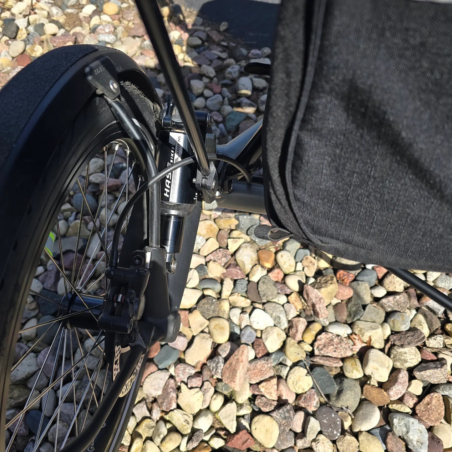 Closeup view of the rear suspension and rear wheel on the Hase Used 2022 Kettwiesel Evo Steps 6100 with 630wh Battery and 2A Charger Recumbent Trike in an outdoor setting.
