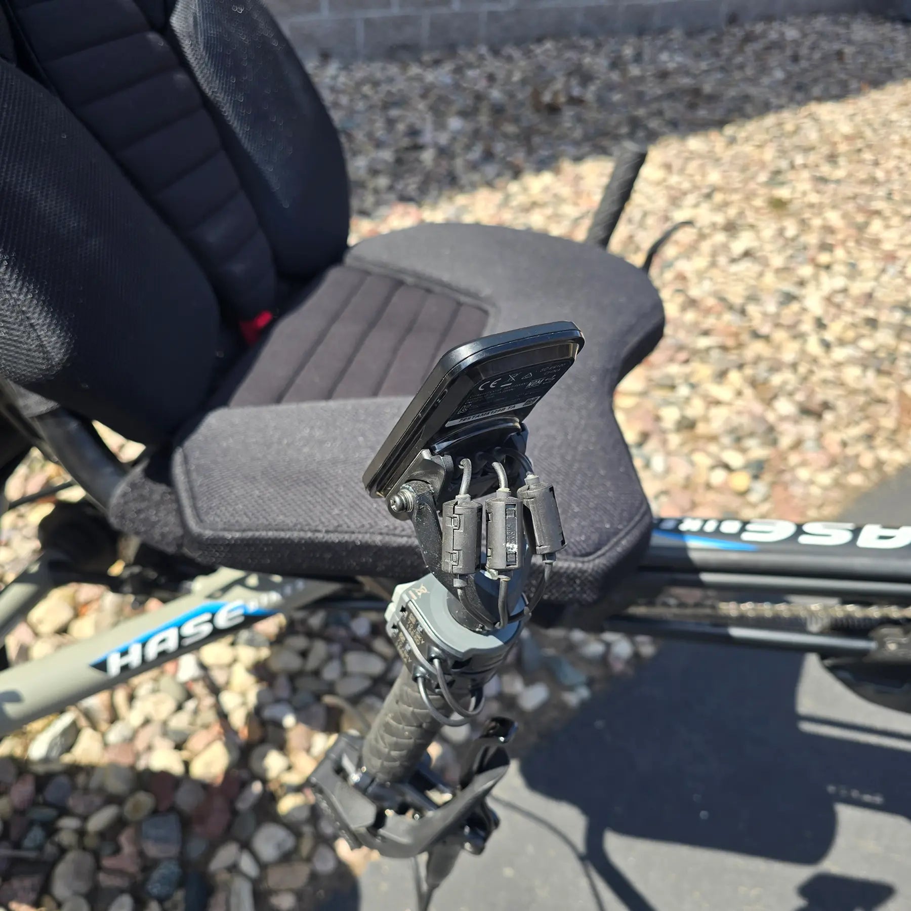 Closeup view of the handlebar and console on the Hase Used 2022 Kettwiesel Evo Steps 6100 with 630wh Battery and 2A Charger Recumbent Trike in an outdoor setting.