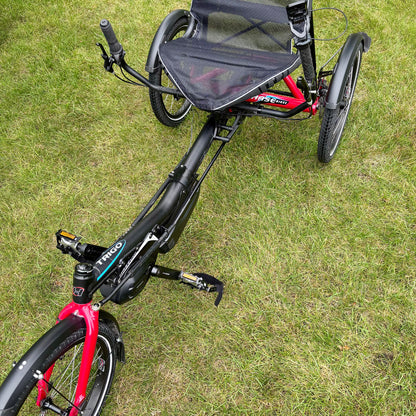 Close-up of three-wheeled Hase Trigo recumbent trike on grass.