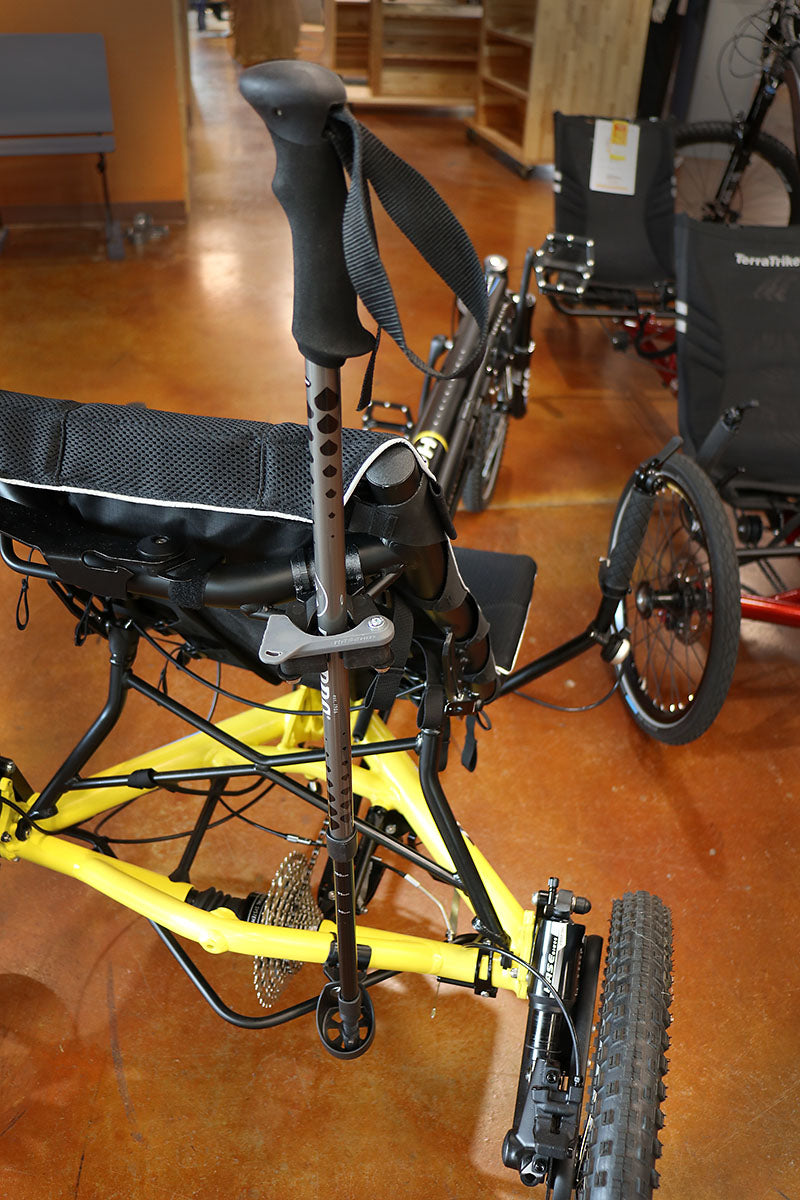 Back angle of a Hase Walking Stick Mount securing a walking stick while attached to a yellow recumbent trike. 