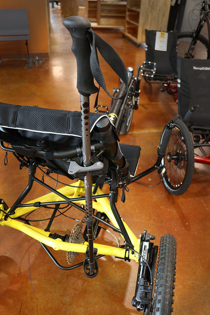 Back angle of a Hase Walking Stick Mount securing a walking stick while attached to a yellow recumbent trike. 