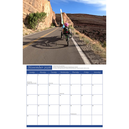 Calendar page for November 2026 with a scenic road and recumbent trikers.