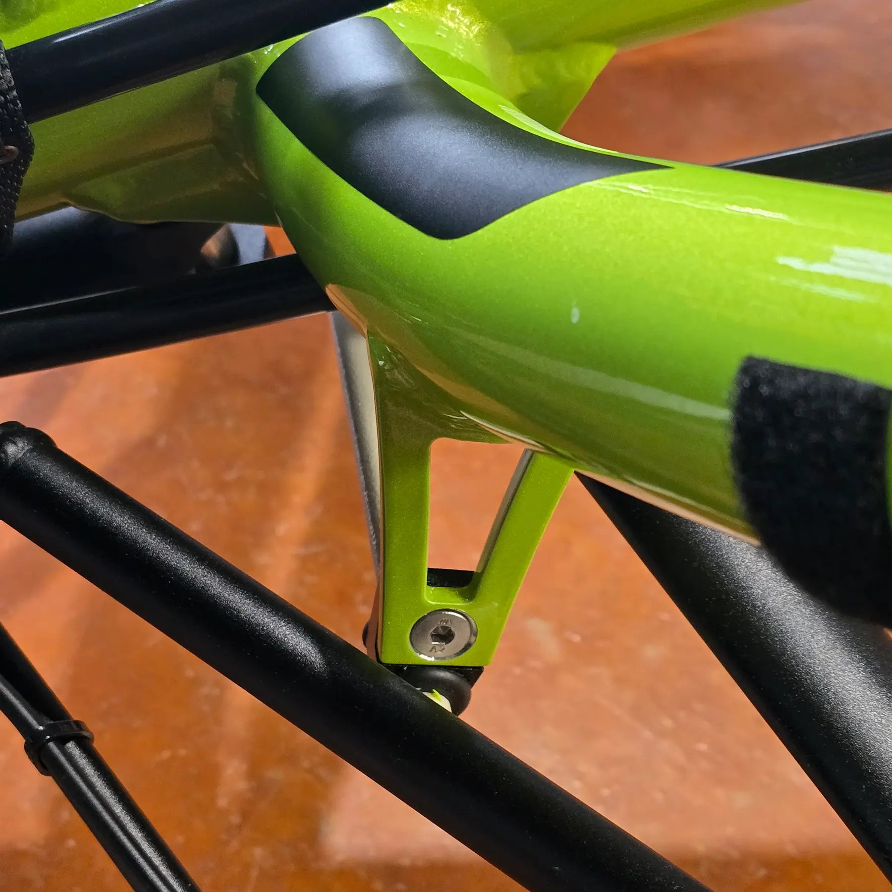 View of the HP Velotechnik Bolt for Front Suspension Stabilizer Bracket on a green front suspended trike.
