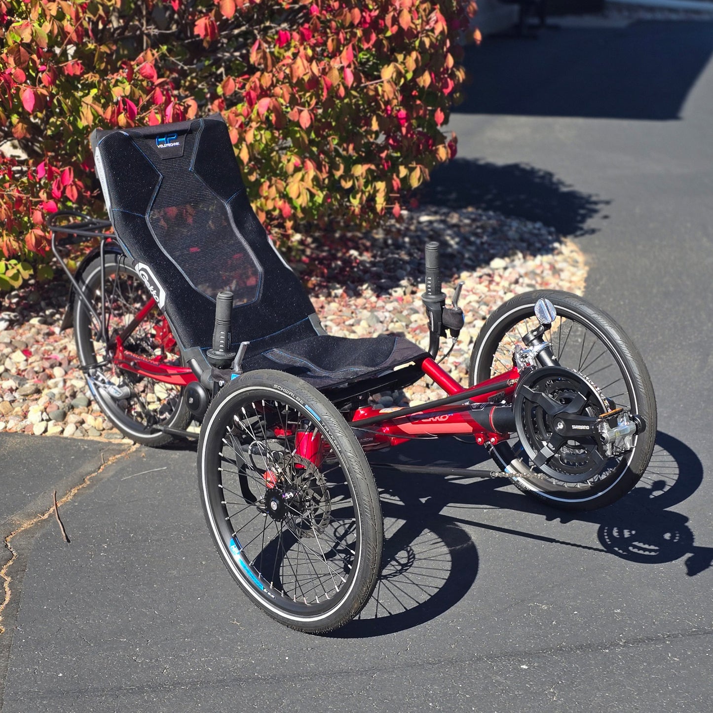 Front angled view of the HP Velotechnik Used Gekko fx 20 Recumbent Trike in Magma Red in an outdoor setting.