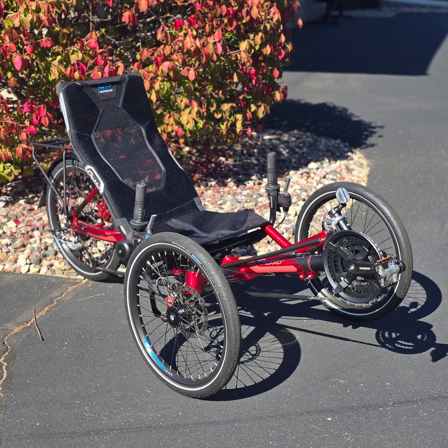 Front angled view of the HP Velotechnik Used Gekko fx 20 Recumbent Trike in Magma Red in an outdoor setting.