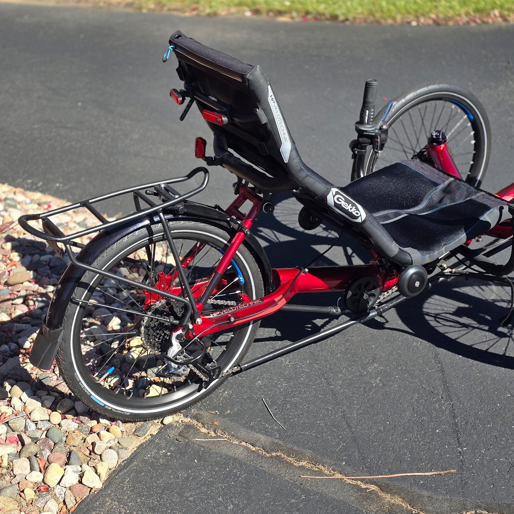 Rear view of the HP Velotechnik Used Gekko fx 20 Recumbent Trike in Magma Red in an outdoor setting.