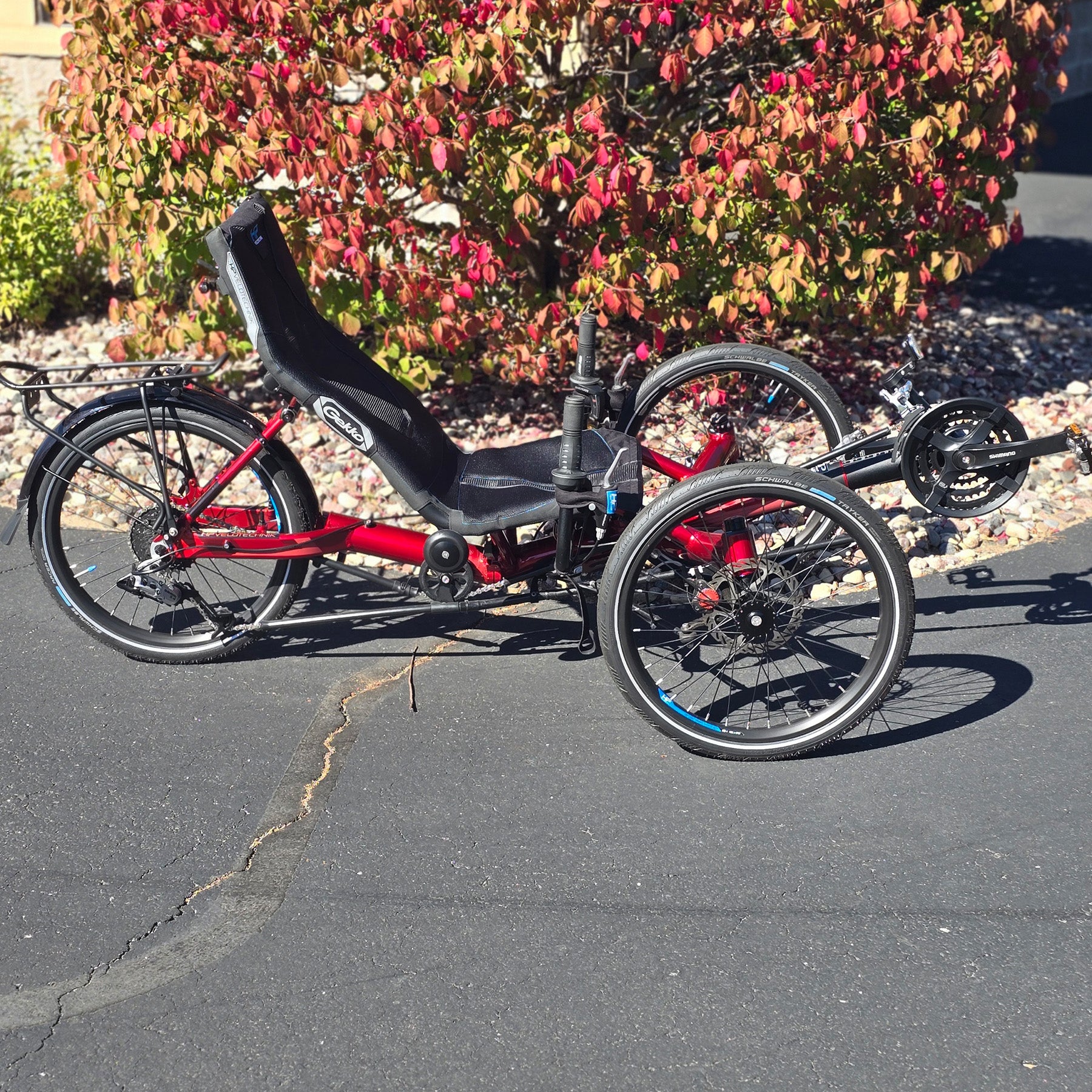 Side view of the HP Velotechnik Used Gekko fx 20 Recumbent Trike in Magma Red in an outdoor setting.