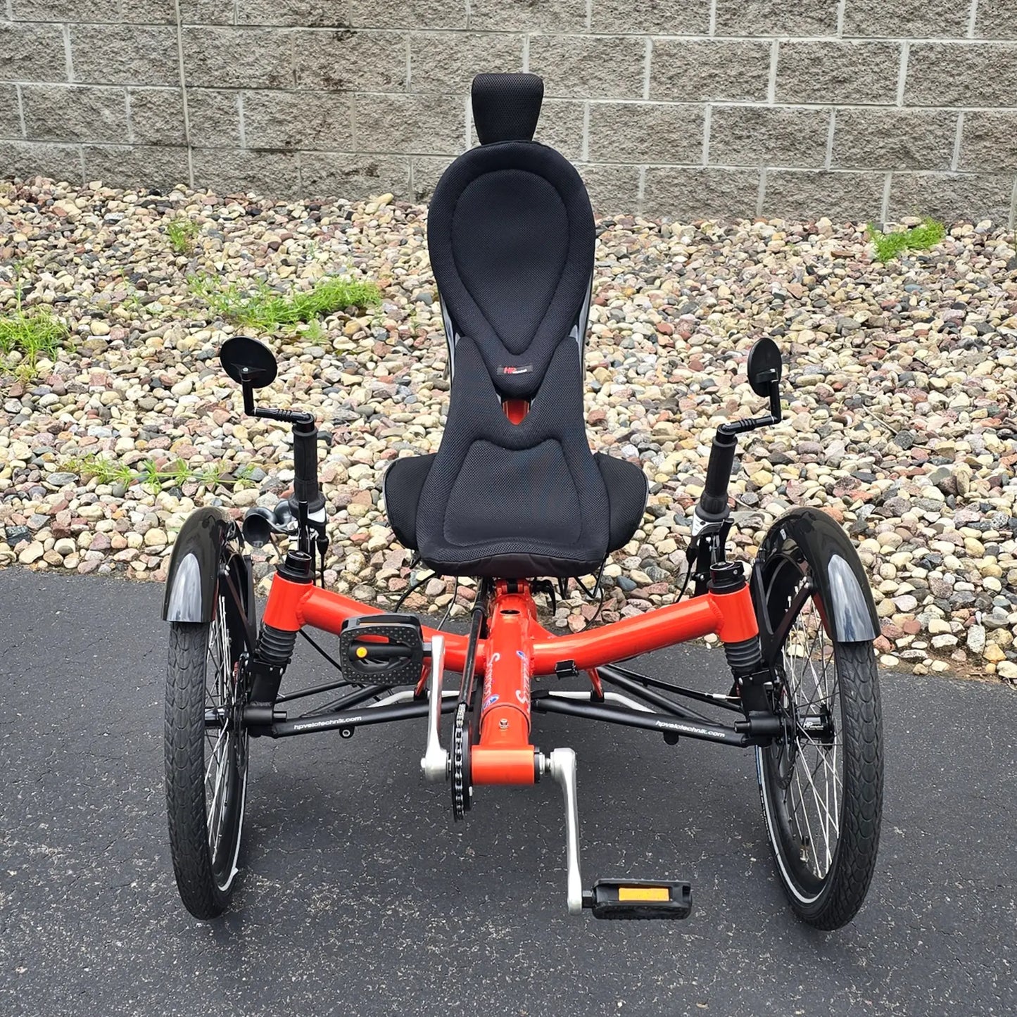 Front view of the HP Velotechnik Used Scorpion fs 20 Orange Recumbent Trike in an outdoor setting.