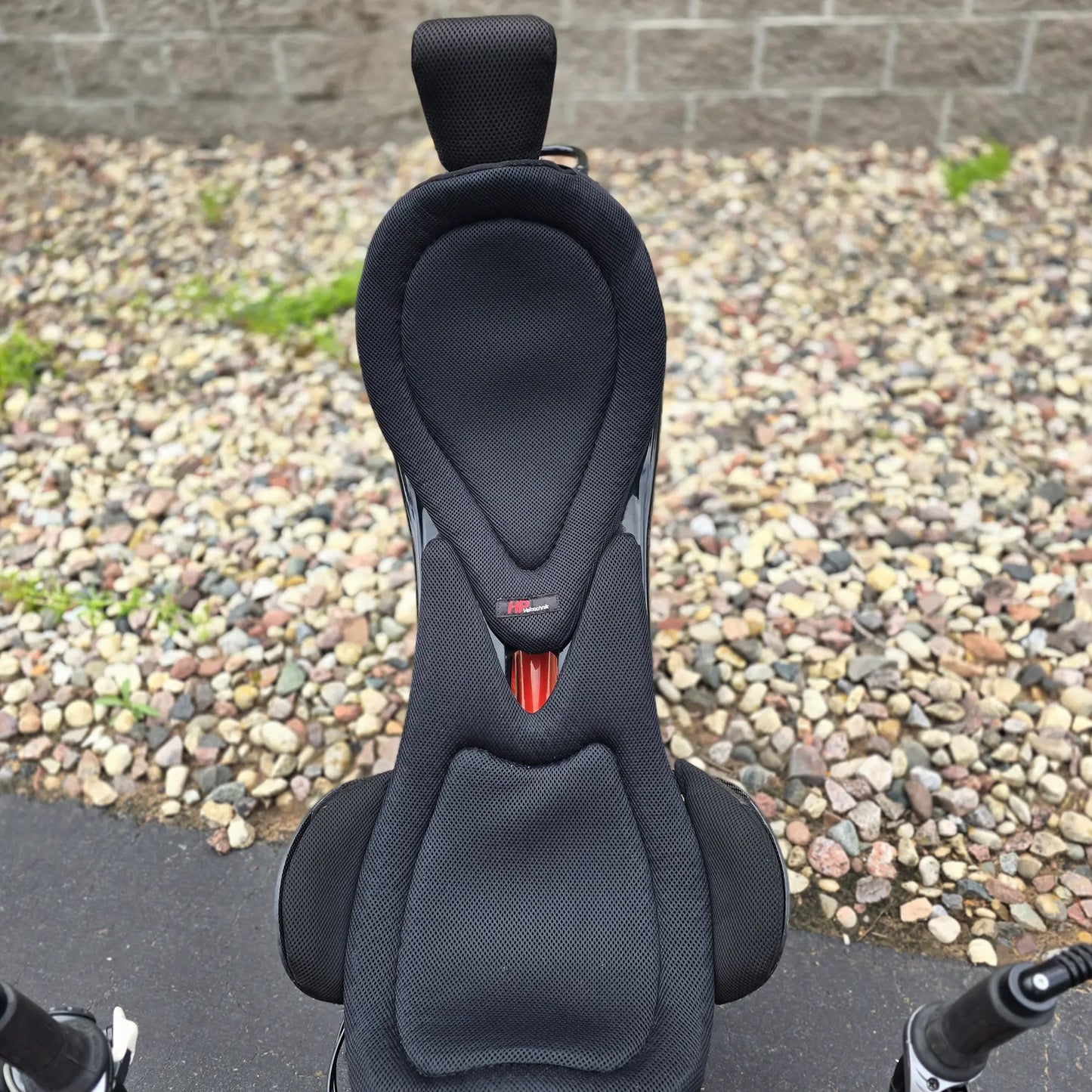 Closeup view of the seat and headrest on the HP Velotechnik Used Scorpion fs 20 Orange Recumbent Trike in an outdoor setting. 