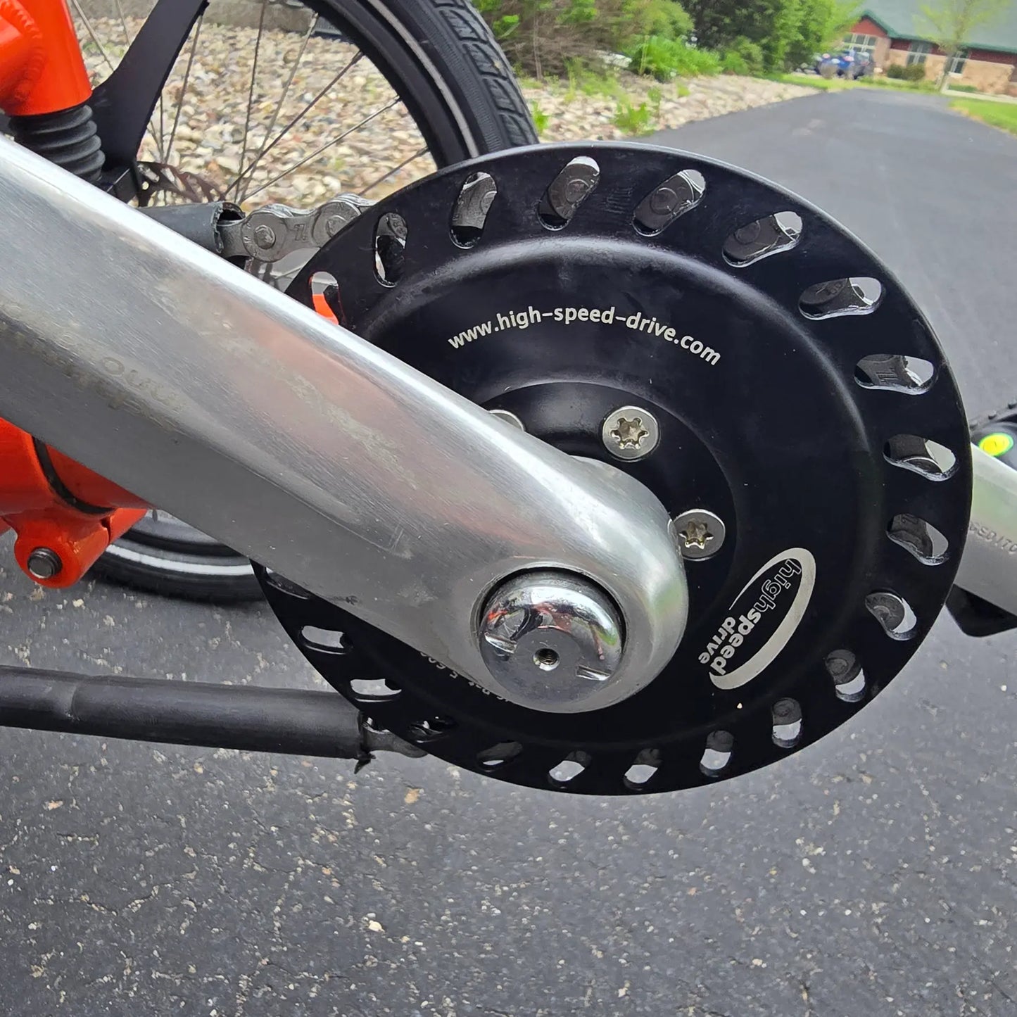 Closeup view of the Schlumpf High Speed drive on the HP Velotechnik Used Scorpion fs 20 Orange Recumbent Trike in an outdoor setting. 