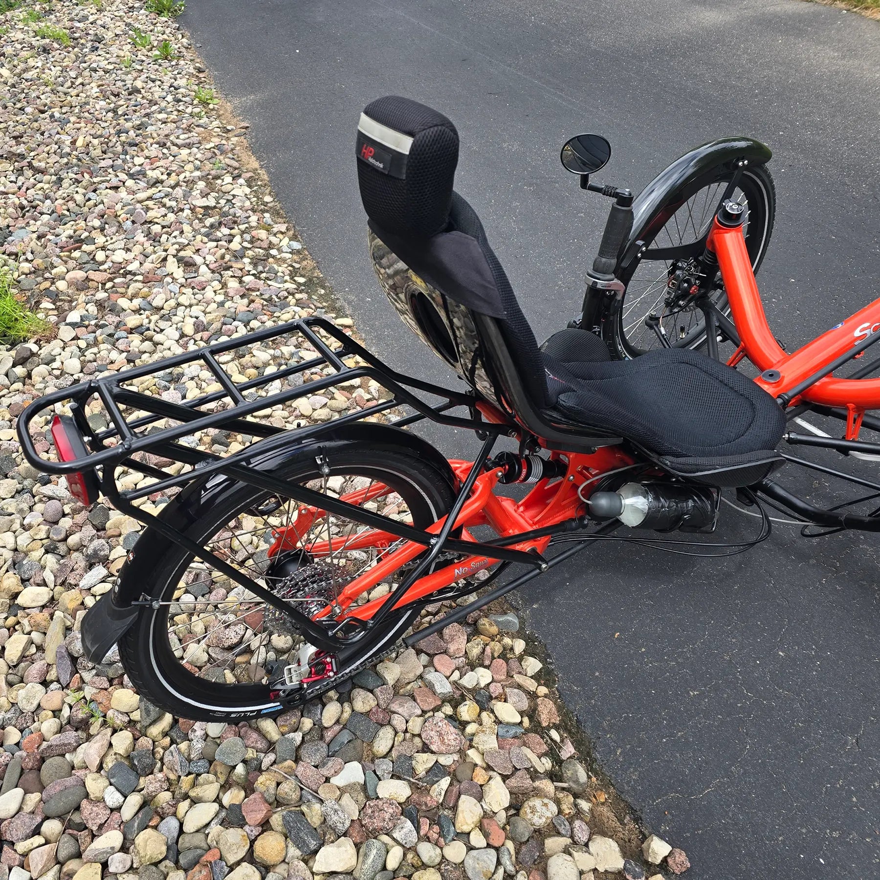 Closeup view of the rear rack and back of the HP Velotechnik Used Scorpion fs 20 Orange Recumbent Trike in an outdoor setting.