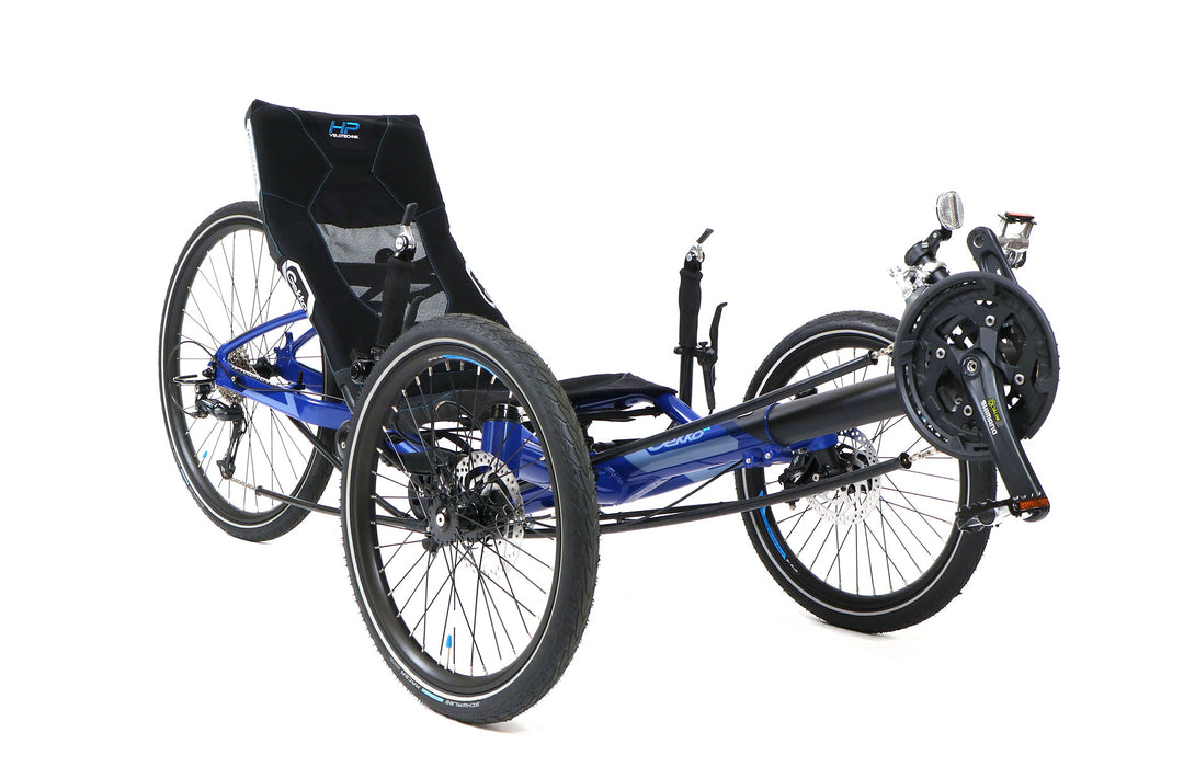 HP Velotechnik recumbent trike with 26 inch rear wheel and 20 inch front wheels in blue frame, front right profile view focusing on chainring and front wheels 