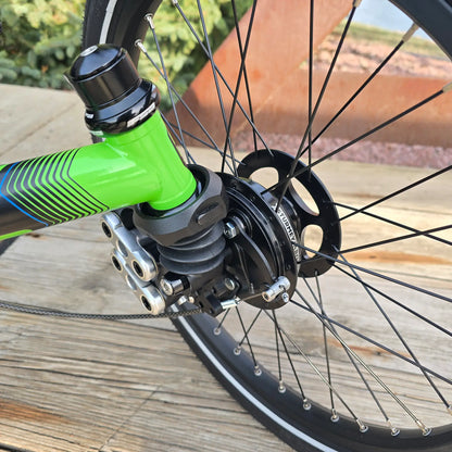 Closeup view of the front suspension on the ICE Adventure HD 26 FS PERS Chainless Kiwi Green Recumbent Trike on a bike path.