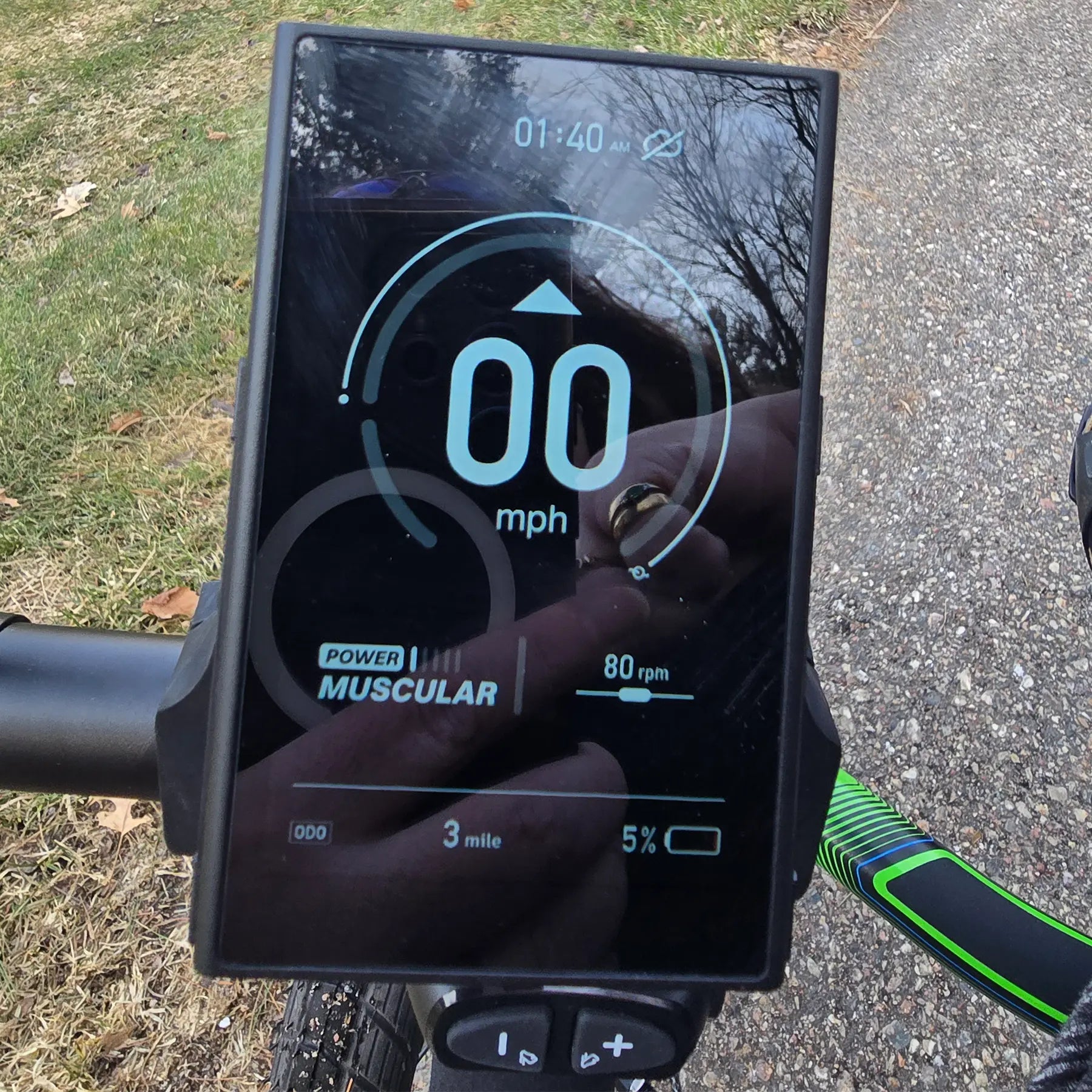 Closeup view of the display screen and e-assist level buttons on the ICE Adventure HD 26 FS PERS Chainless Kiwi Green Recumbent Trike on a bike path.