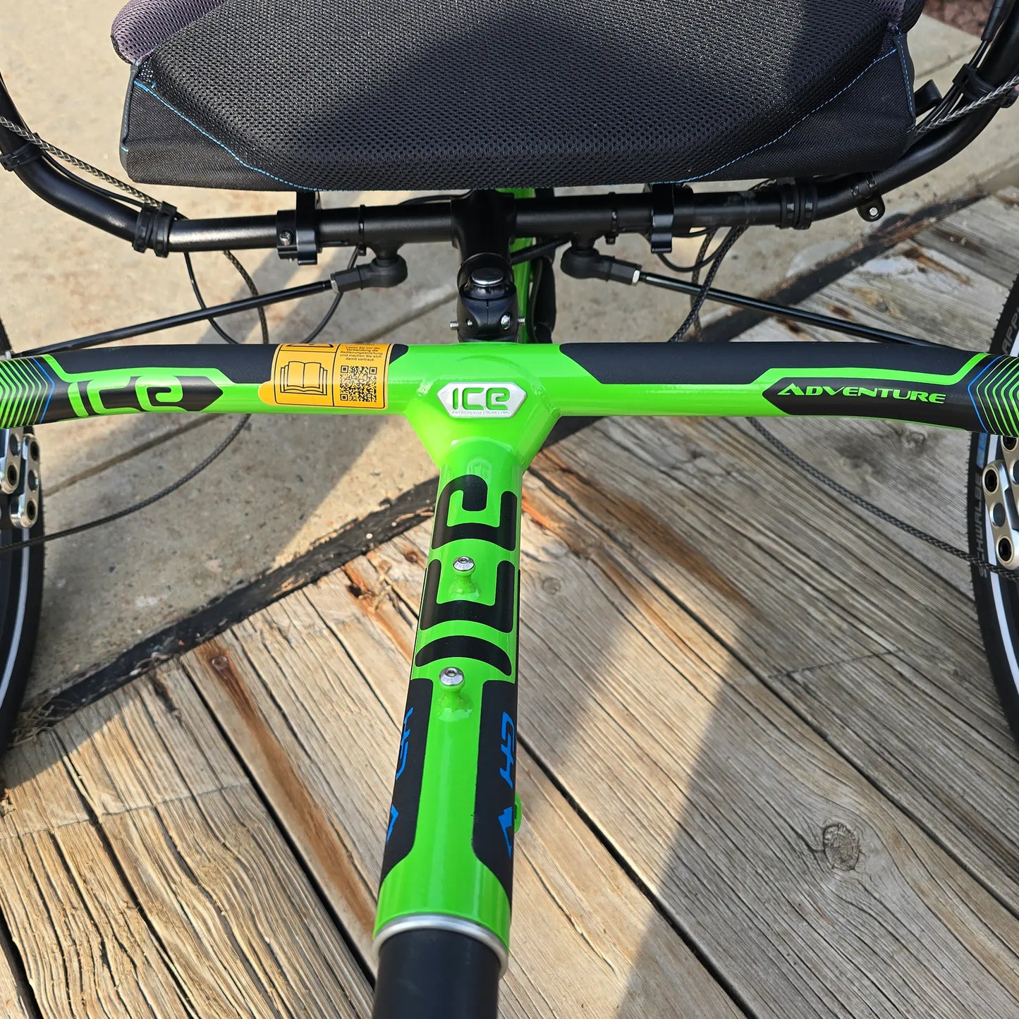 Closeup front view of the frame on the ICE Adventure HD 26 FS PERS Chainless Kiwi Green Recumbent Trike on a bike path.