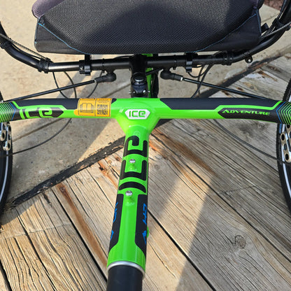 Closeup front view of the frame on the ICE Adventure HD 26 FS PERS Chainless Kiwi Green Recumbent Trike on a bike path.