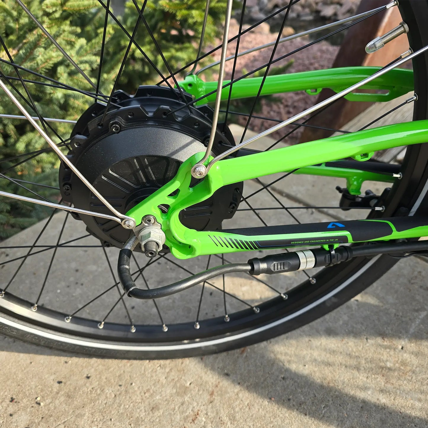 Closeup view of the rear wheel on the ICE Adventure HD 26 FS PERS Chainless Kiwi Green Recumbent Trike on a bike path.
