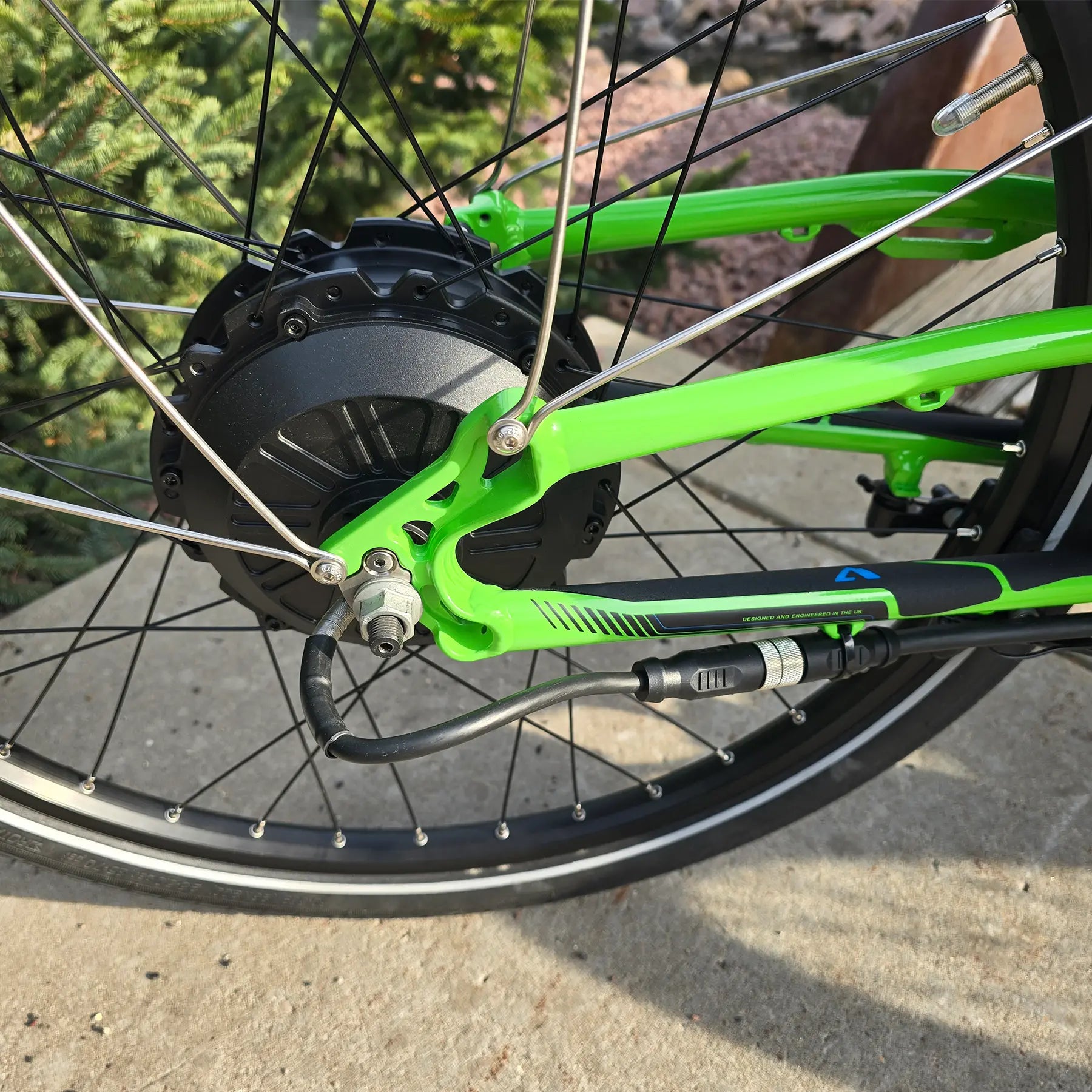 Closeup view of the rear wheel on the ICE Adventure HD 26 FS PERS Chainless Kiwi Green Recumbent Trike on a bike path.