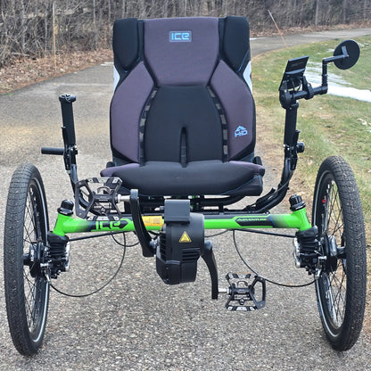 Front view of the ICE Adventure HD 26 FS PERS Chainless Kiwi Green Recumbent Trike on a bike path with trees in the background.