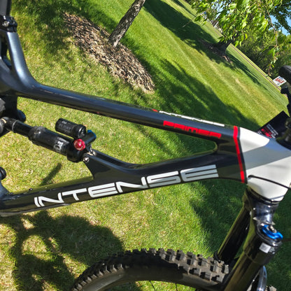 Closeup view of the frame on the INTENSE Primer 29 Pro Midnight Grey-White in an outdoor setting.