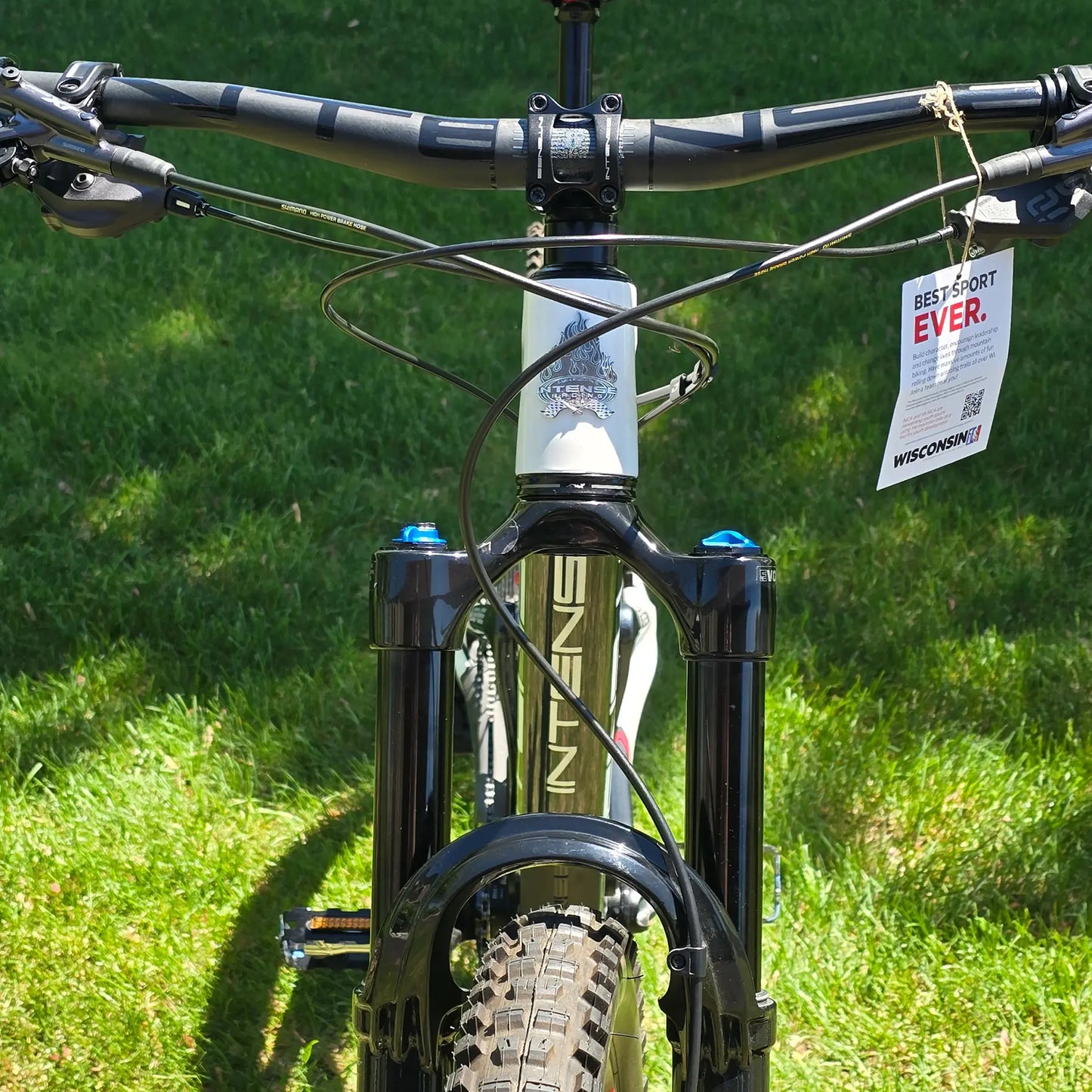 Closeup view of the handlebars and front of the INTENSE Primer 29 Pro Midnight Grey-White in an outdoor setting.