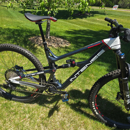 Side view of the INTENSE Primer 29 Pro Midnight Grey-White in an outdoor setting.