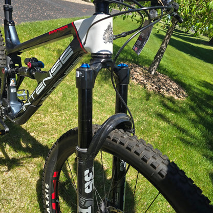 Closeup view of the front of the INTENSE Primer 29 Pro Midnight Grey-White in an outdoor setting.