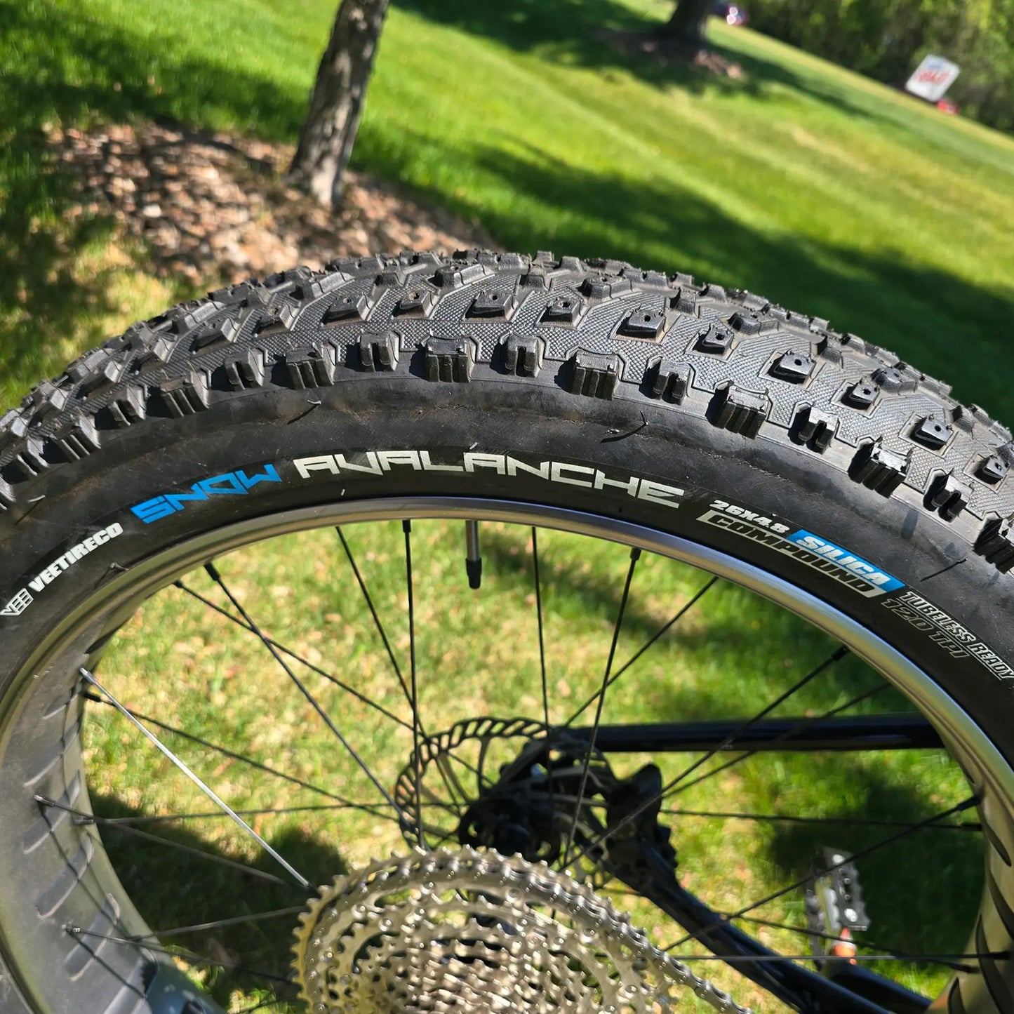 Closeup view of the rear tire on the KHS 4 Season 3000 Fat Bike with Carbon Fork in Black in an outdoor setting.