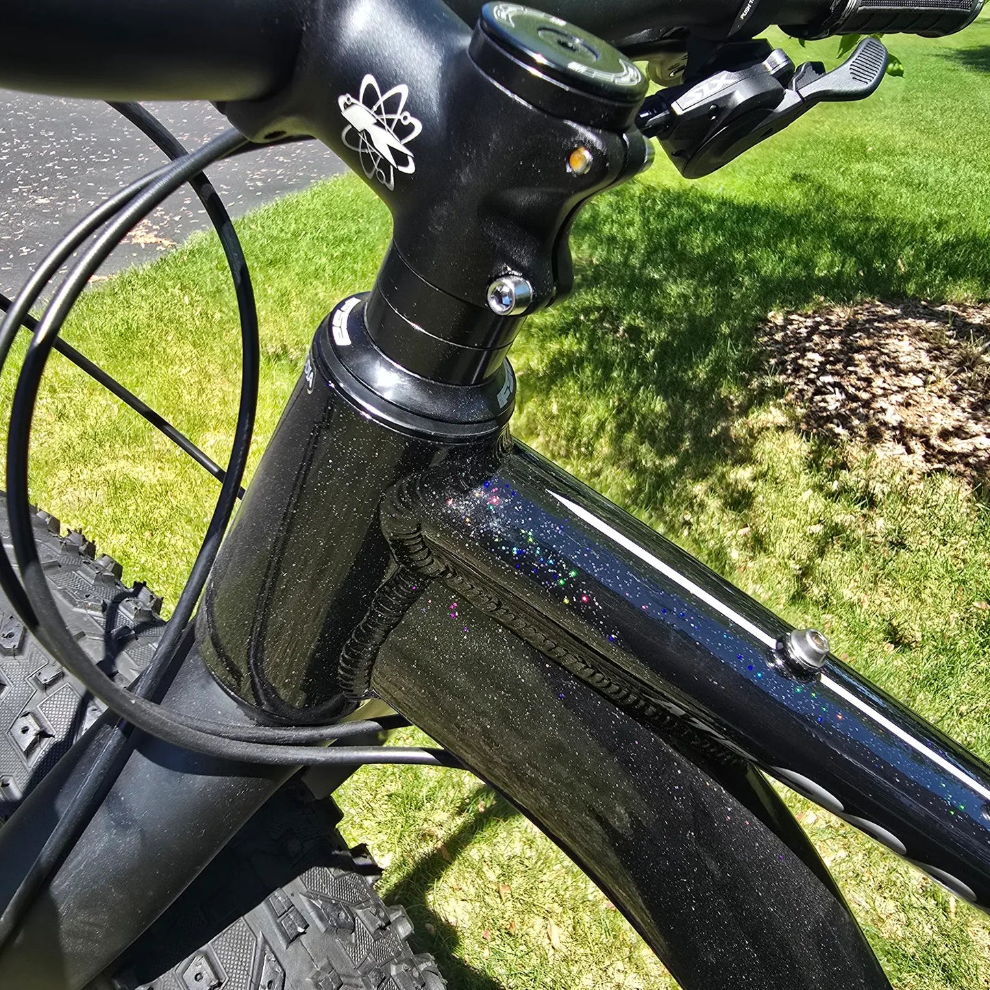 Closeup view of the frame and stem on the KHS 4 Season 3000 Fat Bike with Carbon Fork in Black in an outdoor setting.