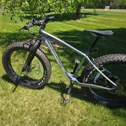 Non-drive side view of the KHS 4 Season 5000 Fat Bike with Carbon Fork in Dark Grey in an outdoor setting.