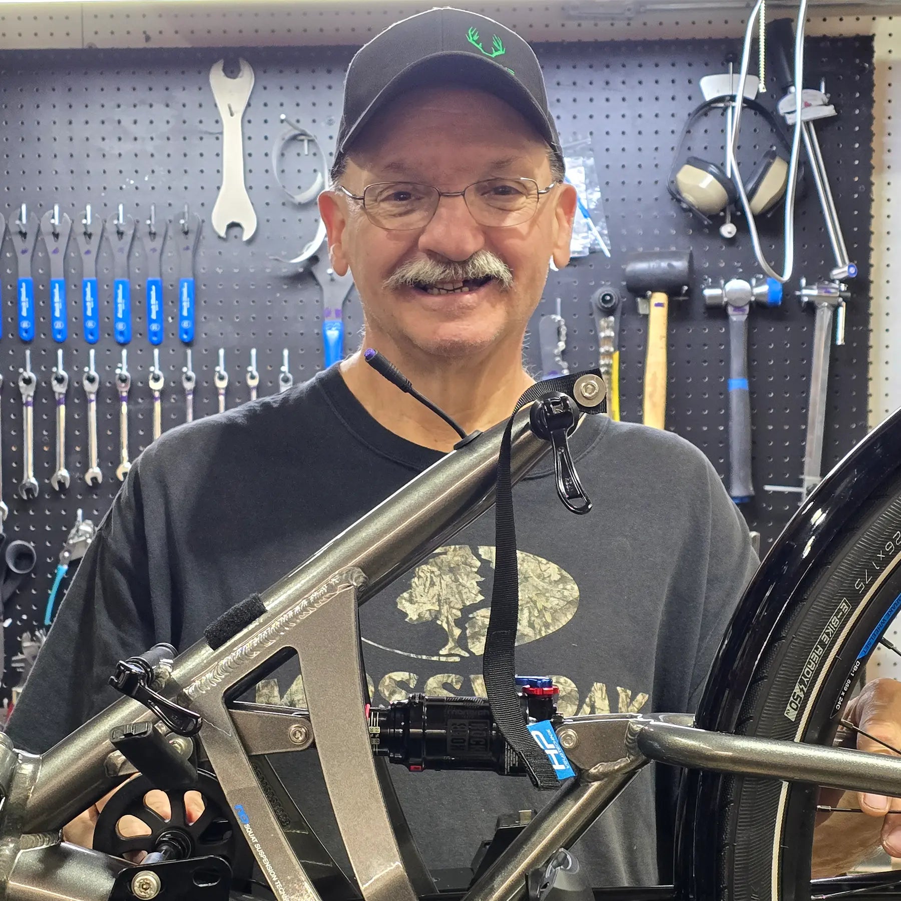 Leon, Mechanic, in front of his work bench and tool board.