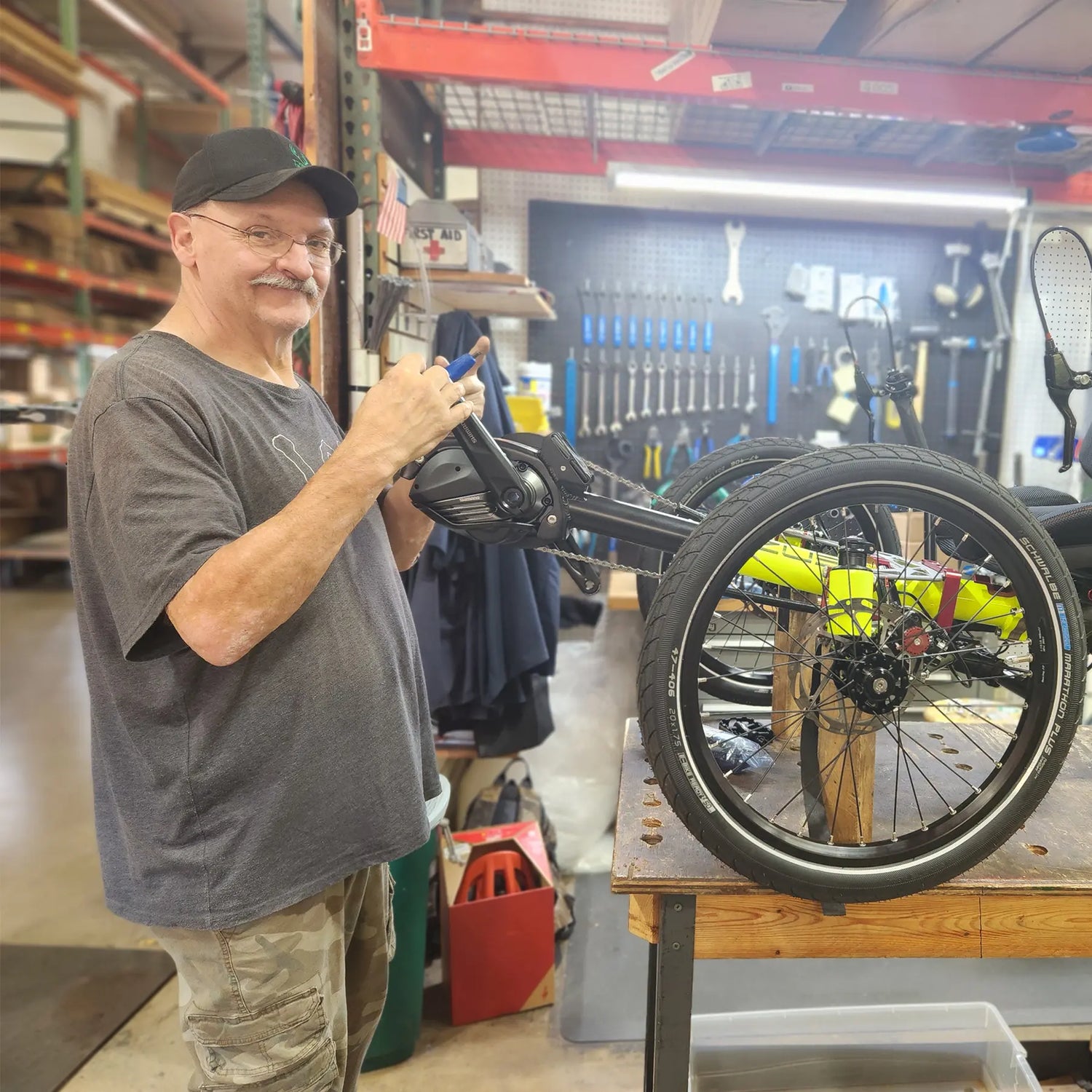 A Hostel Shoppe mechanic repairs a trike.
