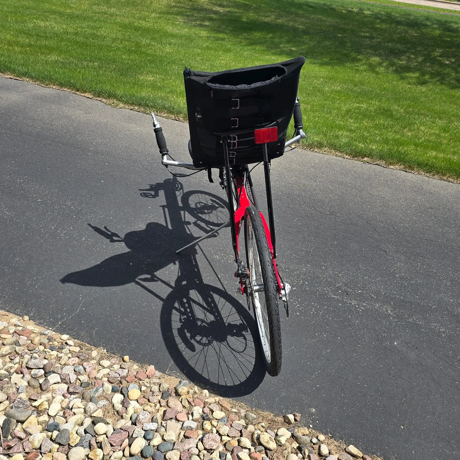 Rear view of the Linear Used Red Recumbent Bike in an outdoor setting.