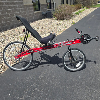 Side view of the Linear Used Red Recumbent Bike in an outdoor setting.