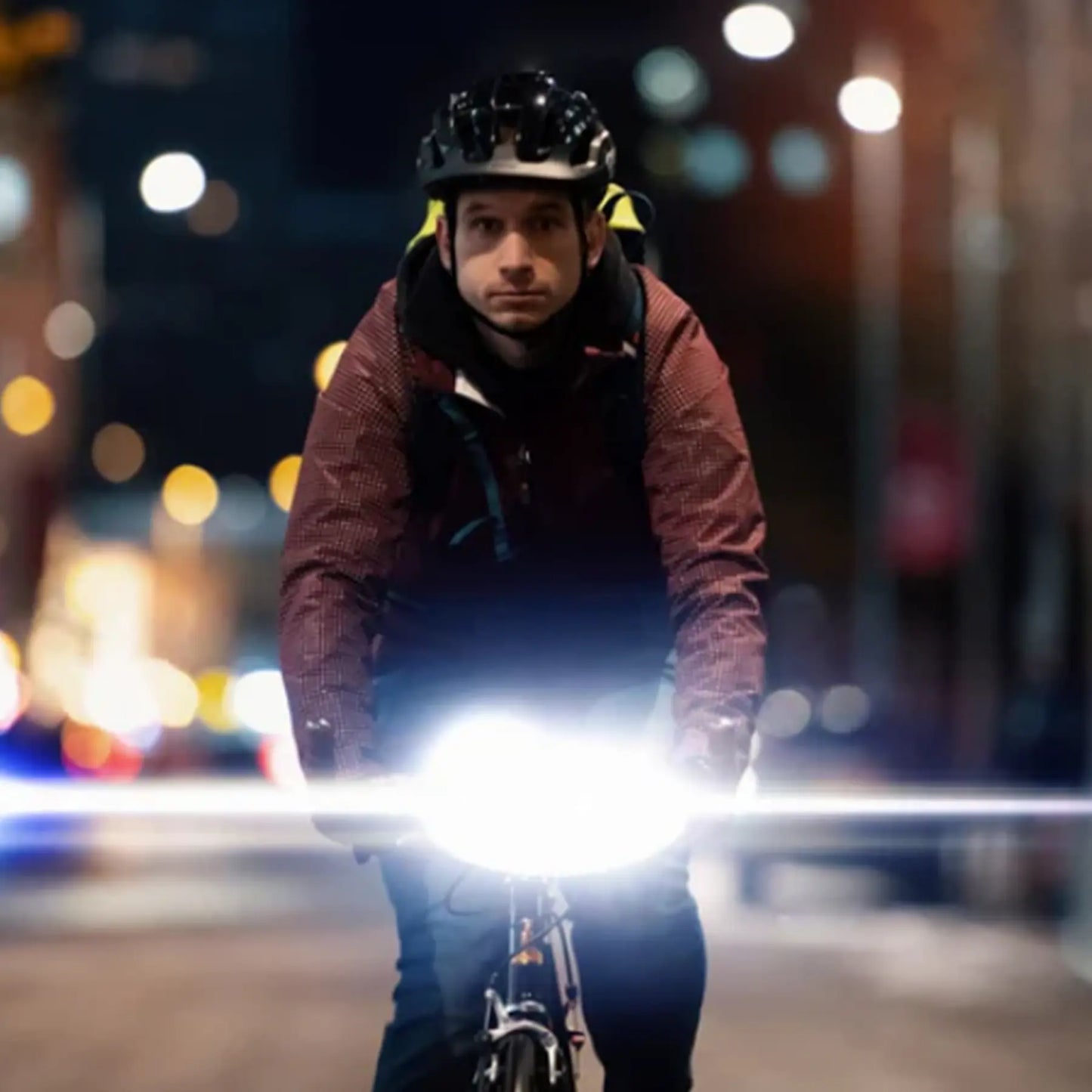 Image of the Moon Rigel Pro 1000 Lumen Headlight lighted up on a bike while a man rides through a city.