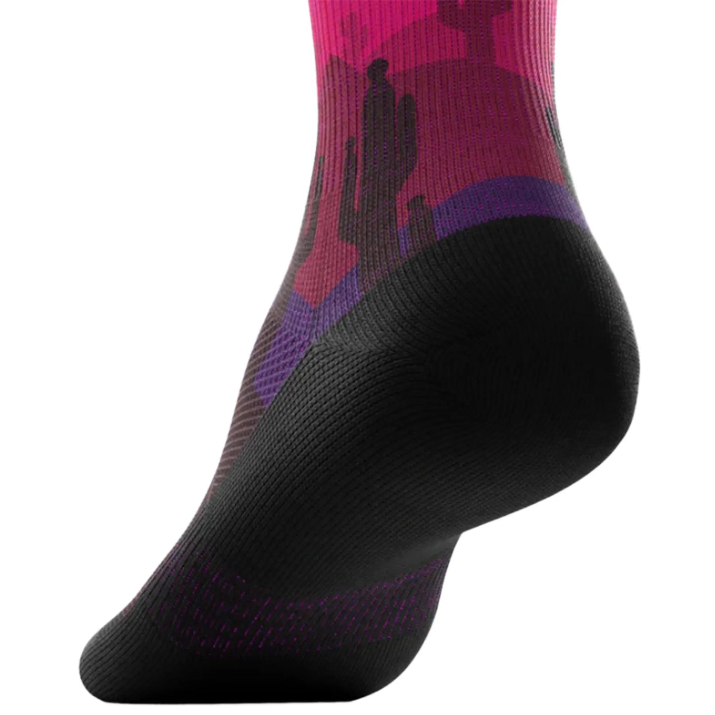 The Outway Dune Crew Socks feature a desert landscape with cactus in pinks, purples and orange, with a blue sky and a yellow sun, while the bottom of the sock is black.