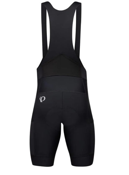 Back view of black Pearl Izumi Expedition bib cycling shorts on a white background. 