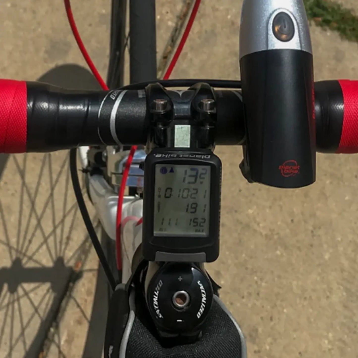 Image of the Planet Bike Protege 9.0 Wireless Bike Computer with 4 lines of display in black mounted on a bicycle.