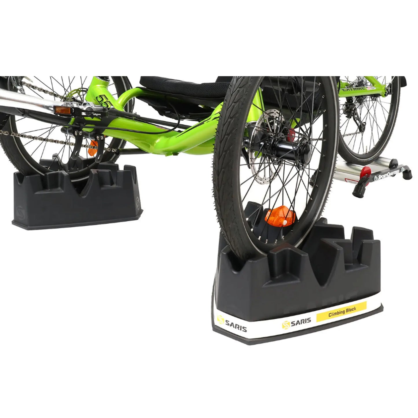 View of two of the Saris Indoor Bike Trainer Climbing Riser Block under a tadpole trikes front wheels against a white background.