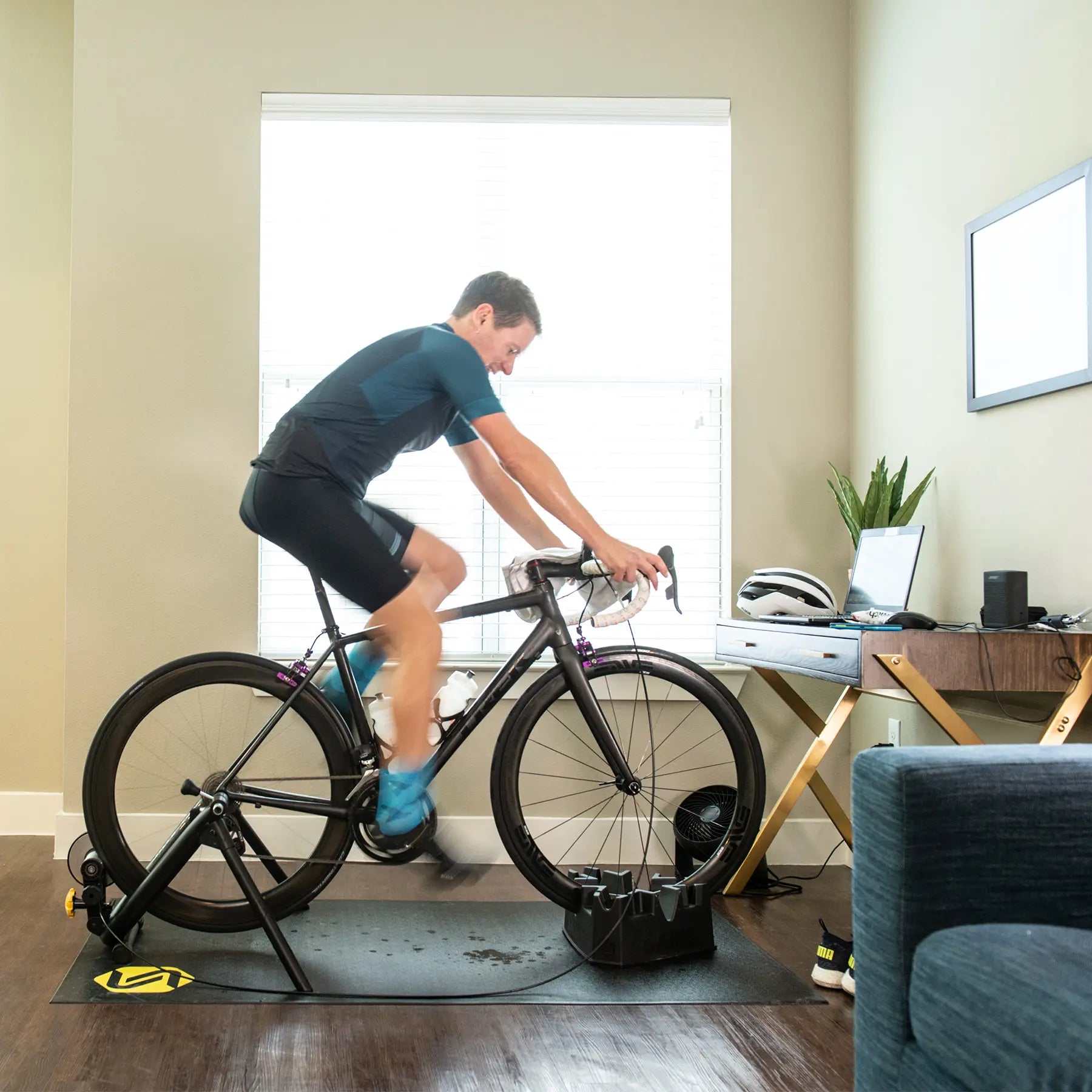 A man rides a bike on a stationary Saris bike trainer.