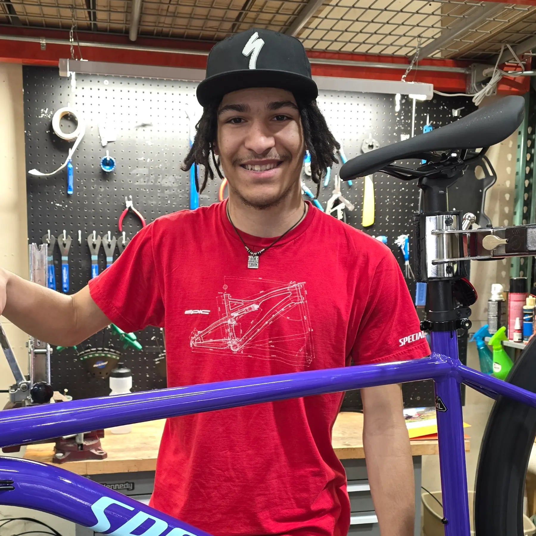 Sebastian, Mechanic, in front of his work bench and tool board.