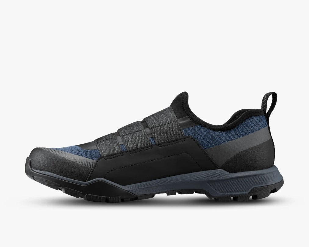 Side view of a black and dark blue Shimano SH-EX700 cycling shoe on a white background.