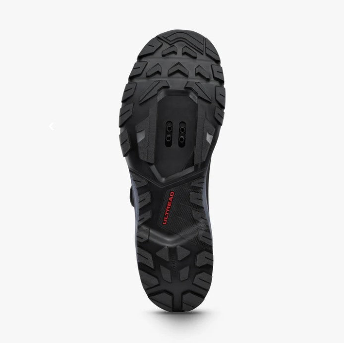 Bottom sole view of a Shimano SH-EX700 cycling shoe showing black tread and cut out for cleats. 