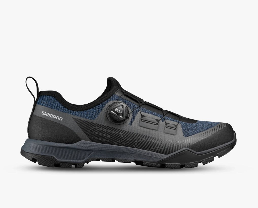View of BOA dial on a black and dark blue Shimano SH-EX700 cycling shoe on a white background.