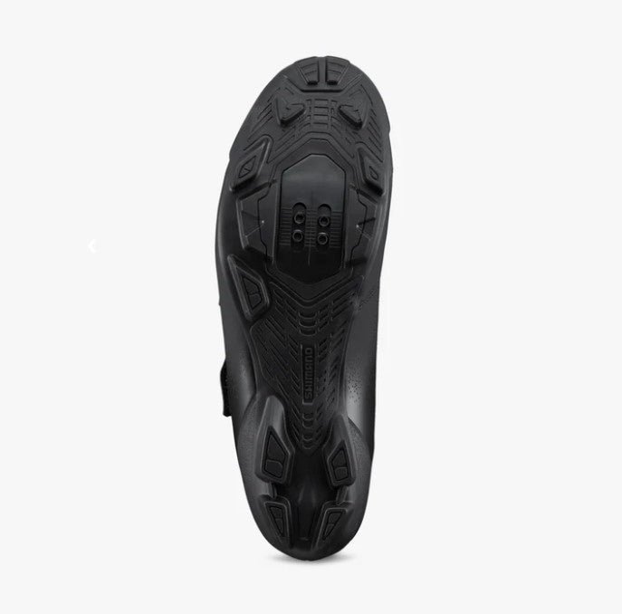 Black Shimano SH-XC102 cycling shoe sole with tread pattern on a white background.