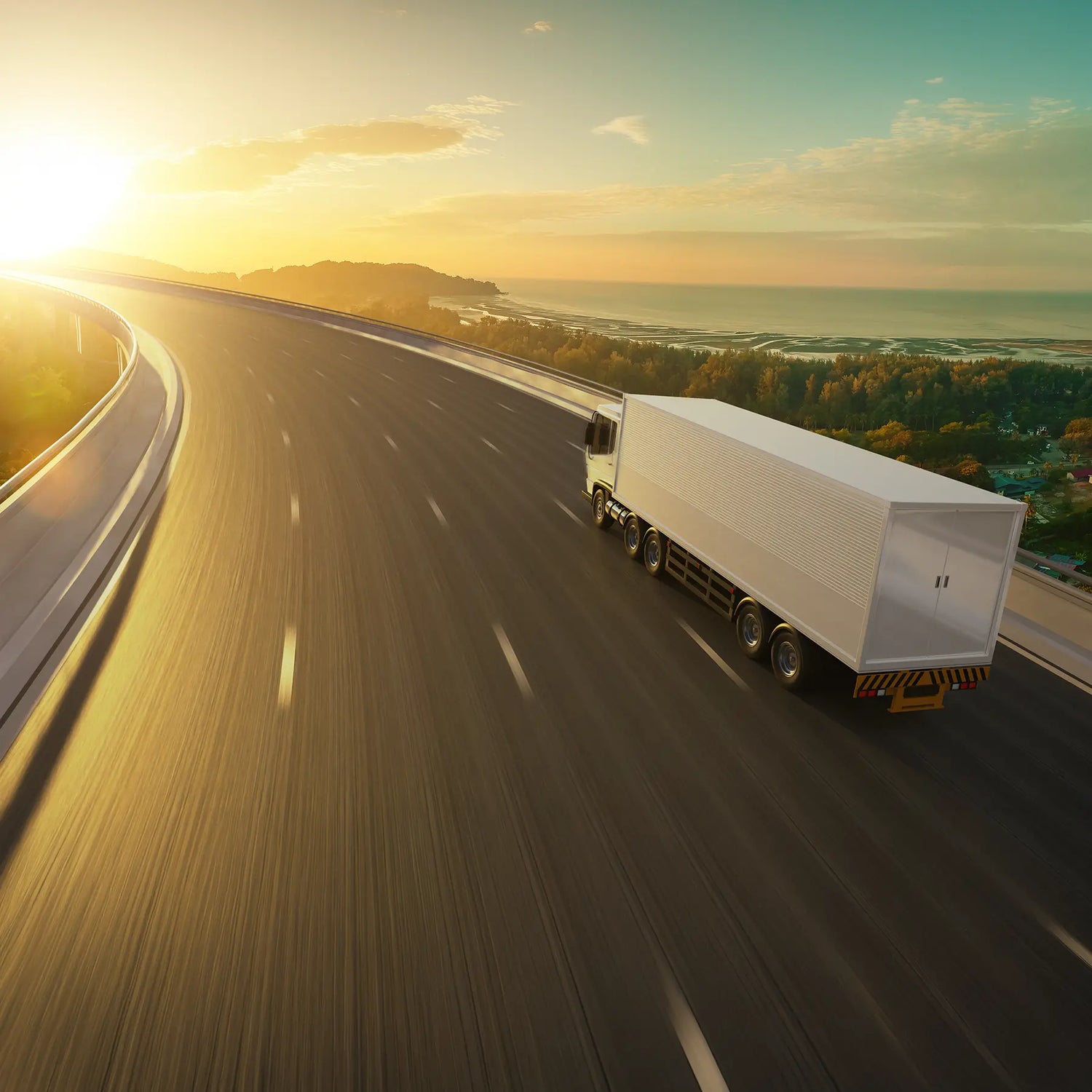 Truck driving on a highway with a scenic sunset in the background