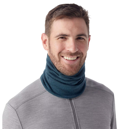 A man wearing the Smartwool Thermal Merino Reversible Pattern Neck Gaiter in Twilight Blue Heather against a white background.