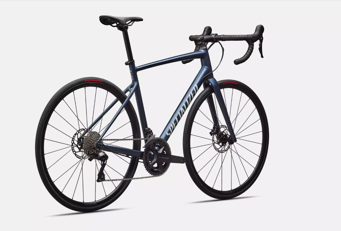 Back angled view of blue Specialized Allez e5 road bicycle on a white background.